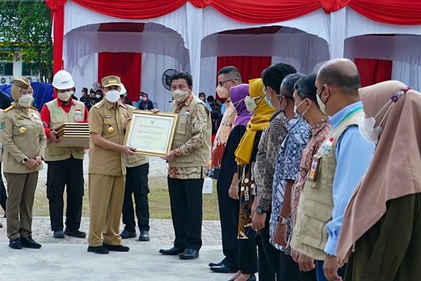 Gubernur Riau Syamsuar menyerahkan piagam penghargaan kepada 10 perusahaan di Provinsi Riau yang membantu pembayaran premi tenaga kerja rentan. 